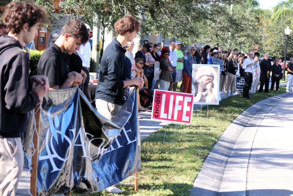 People lined up in prayer along the side of a street
