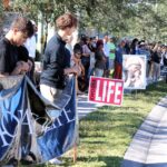 People lined up in prayer along the side of a street